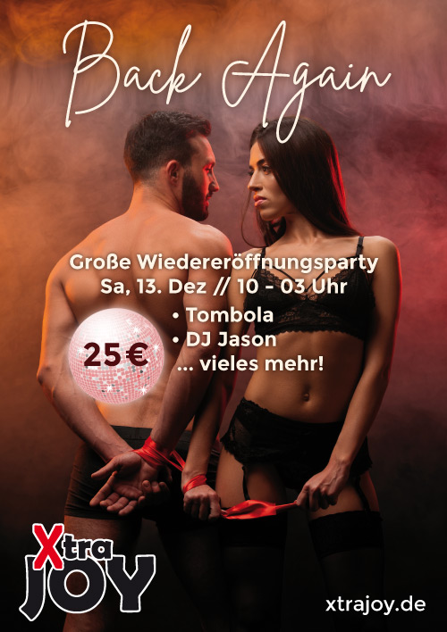 Ein Mann mit Bart und freiem Oberkörper steht neben einer Frau in schwarzer Unterwäsche und beide schauen sich ernst an, während sie rote Bänder halten